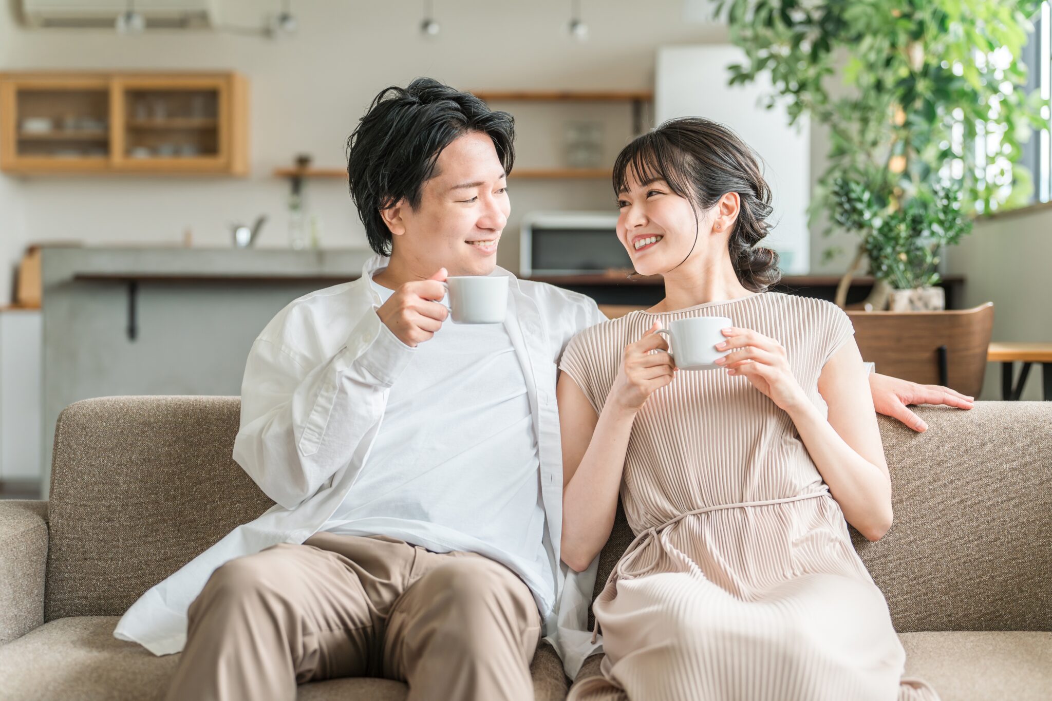 ソファで笑顔で語り合う夫婦